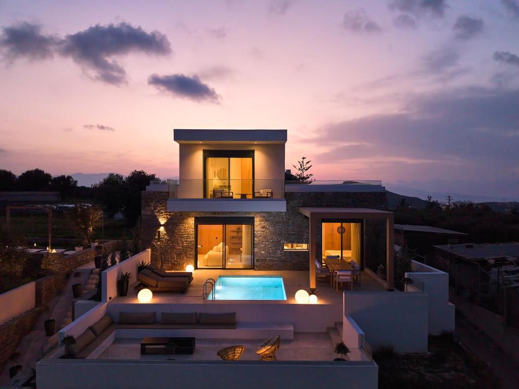 a villa with a swimming pool at dusk at POLYTELIA - Luxury Living in Elaía