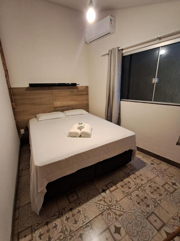 a bedroom with a bed in a room with a window at Kitnet Apart-Hotel 4 in Sete Lagoas
