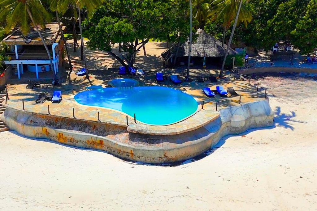 a swimming pool in the middle of a beach at Kusini Beach Cottages in Diani Beach