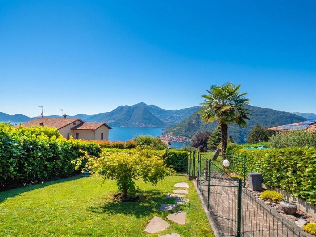a garden with a view of the water and mountains at CasaDolcelago Sulzano Villa con Giardino Vista Lago Parking Free in Sulzano