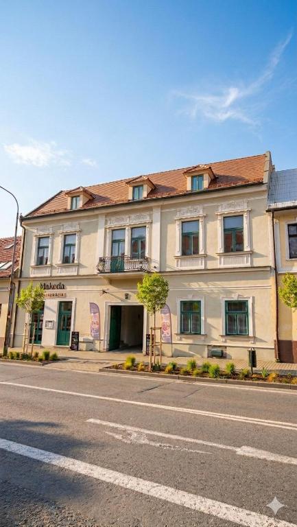 a large white building on the side of a street at Boutique Hotel H23 in Pezinok