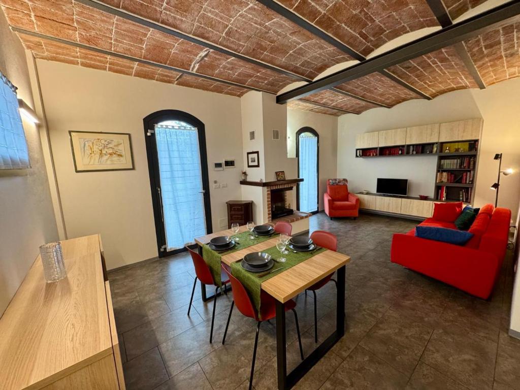 a living room with a table and a red couch at Casa Barovaldo in Zola Predosa