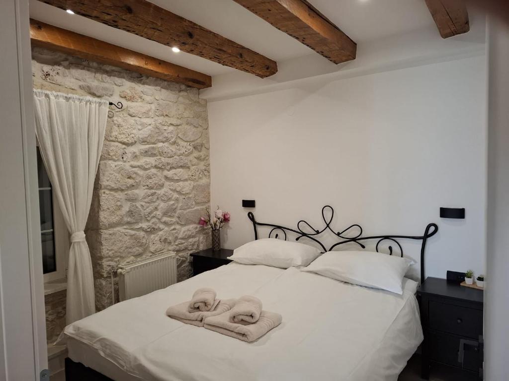 a bedroom with a white bed with towels on it at Apartments Jerko in Primošten