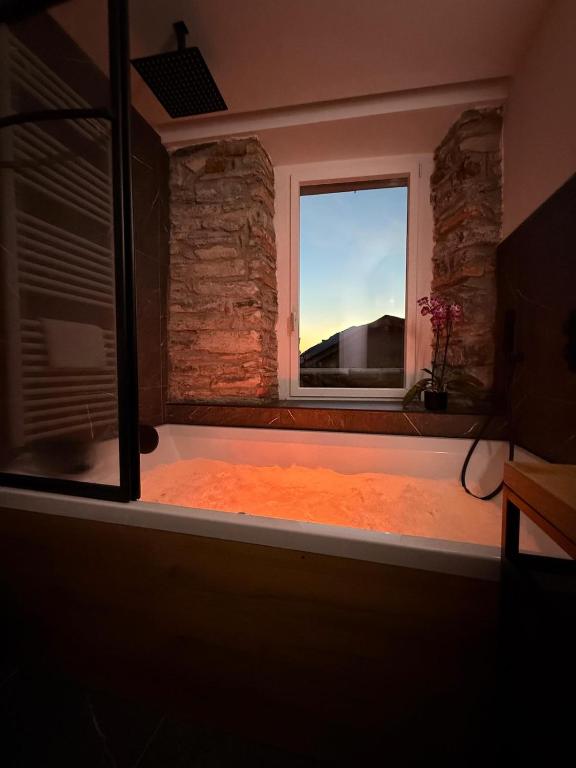 a room with a bath tub with a window at DN ART BLEVIO - Romantic Lake Como Apartment with Indoor Jacuzzi - 5 guests in Blevio