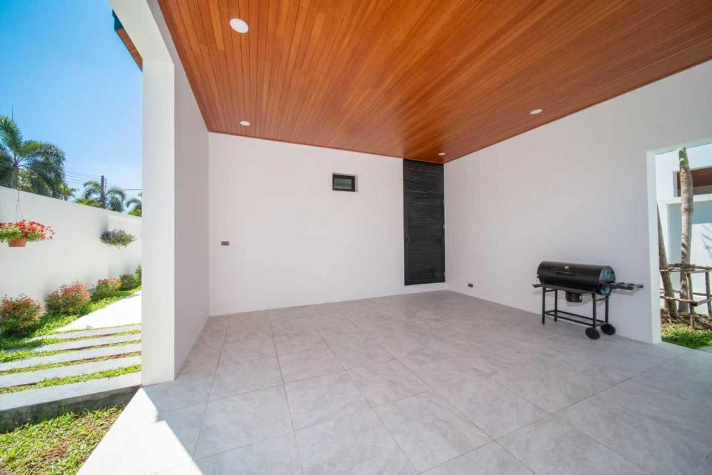 a large patio with a black chair in a room at Yuan Villa VIP in Rawai Beach