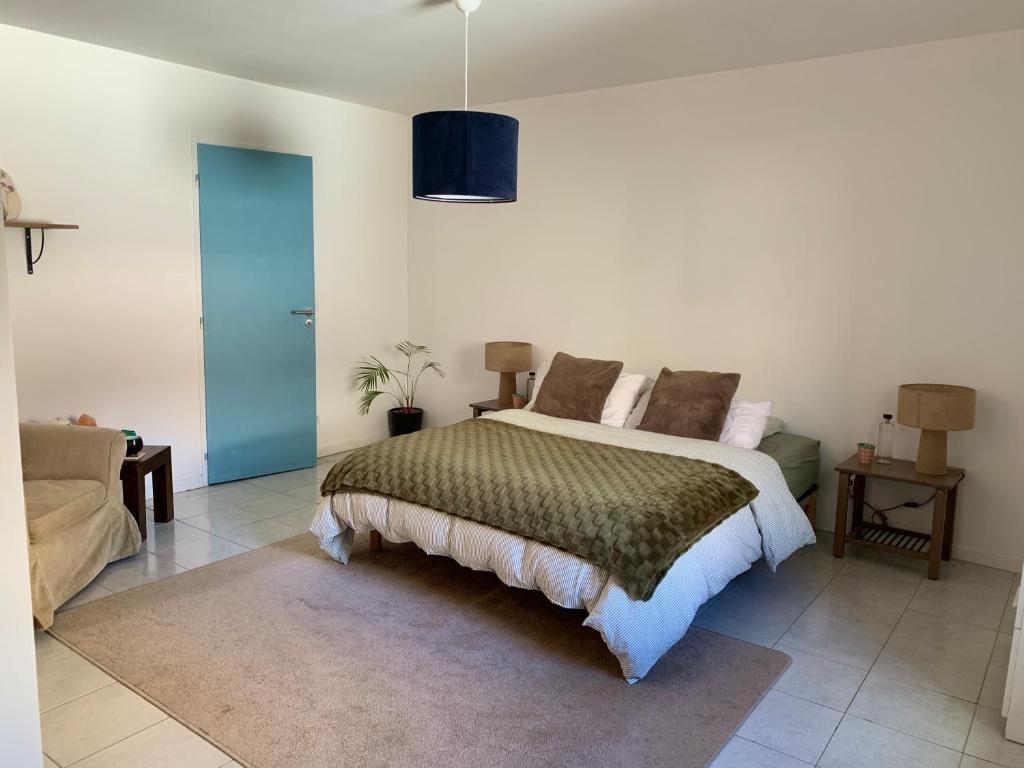 a bedroom with a large bed and a couch at Les Toits d'Aniane in Aniane