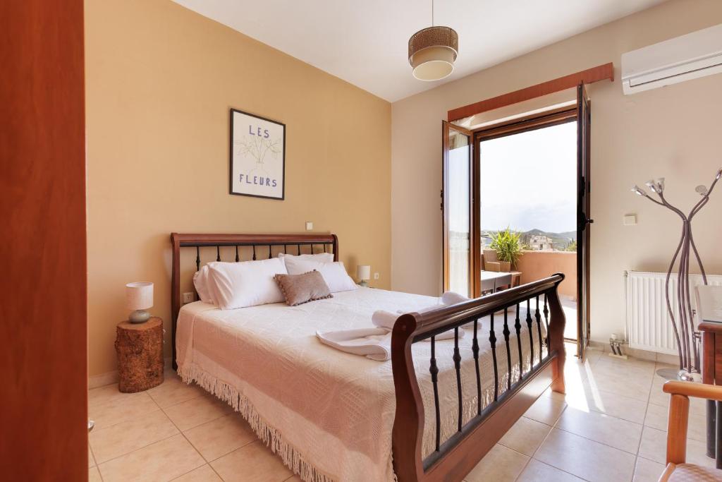 a bedroom with a bed and a balcony at Villa Geomare in Apolakkiá