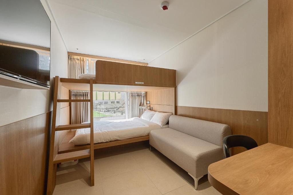 a small bedroom with a bunk bed and a table at Hotel On You in Seoul