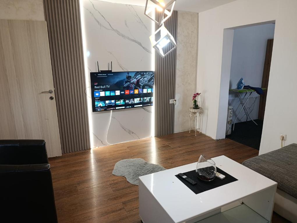 a living room with a white table and a tv at V&J apartments in Podgorica
