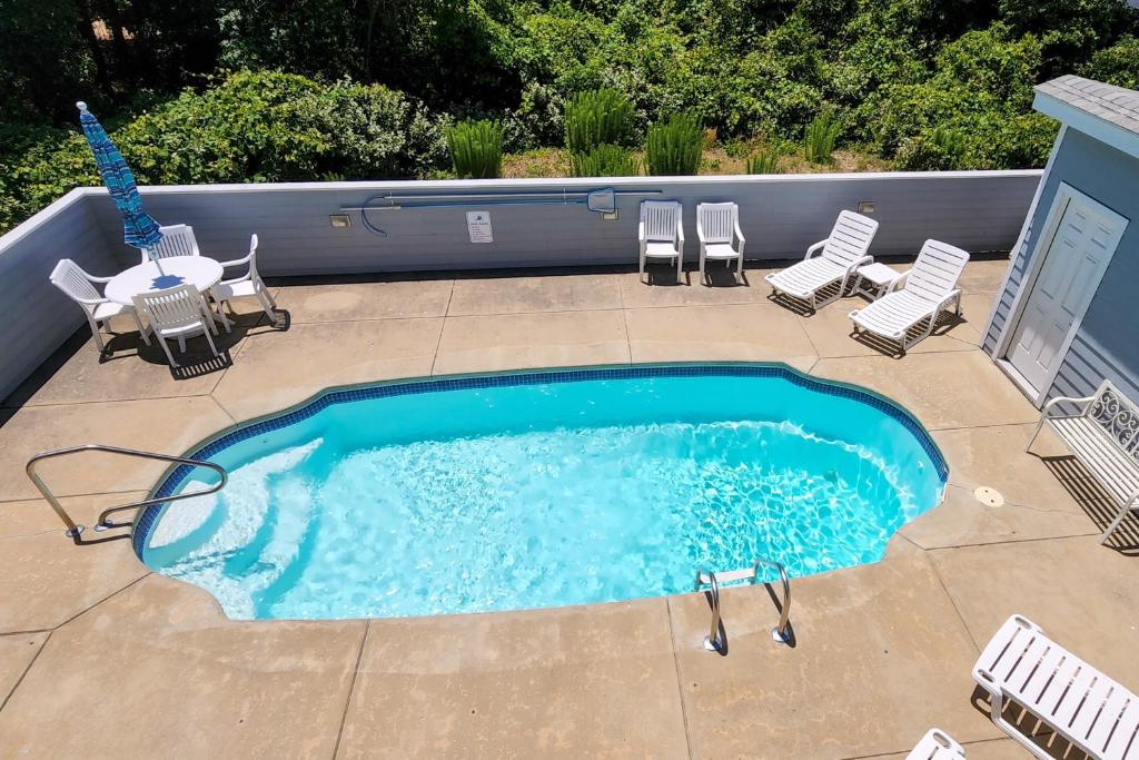 a small swimming pool with chairs and a table at Dock Holiday OBX Village in Duck