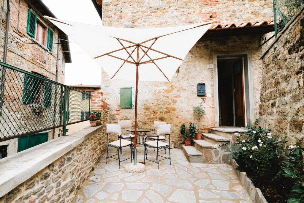 a patio with a table and an umbrella at historical townhome in Poppi in Poppi