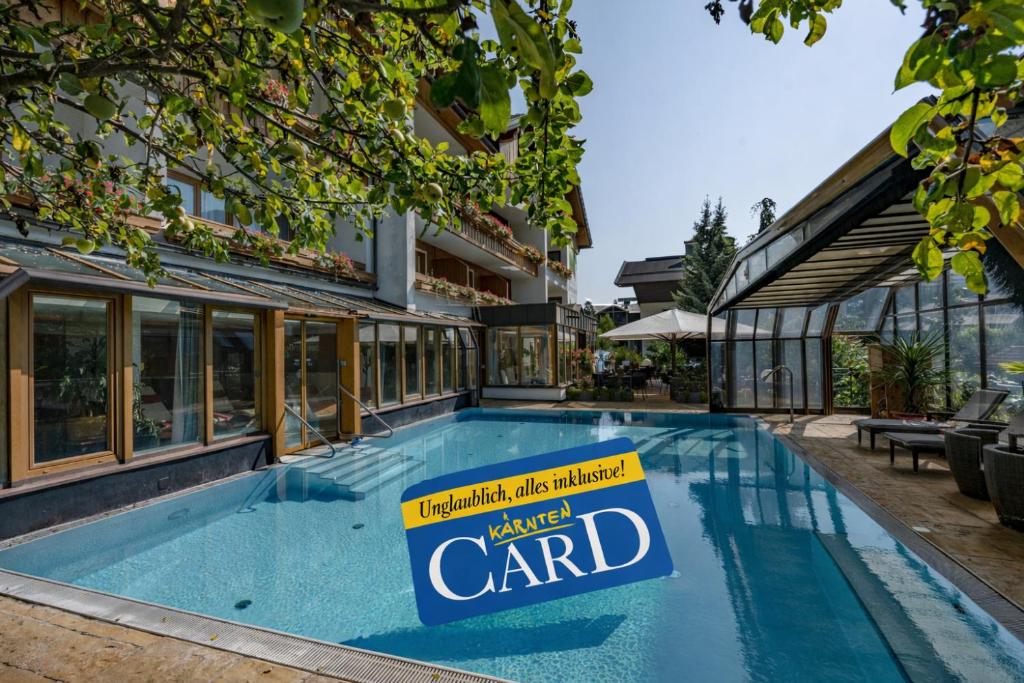 a sign in a swimming pool in front of a building at Genusshotel Almrausch in Bad Kleinkirchheim
