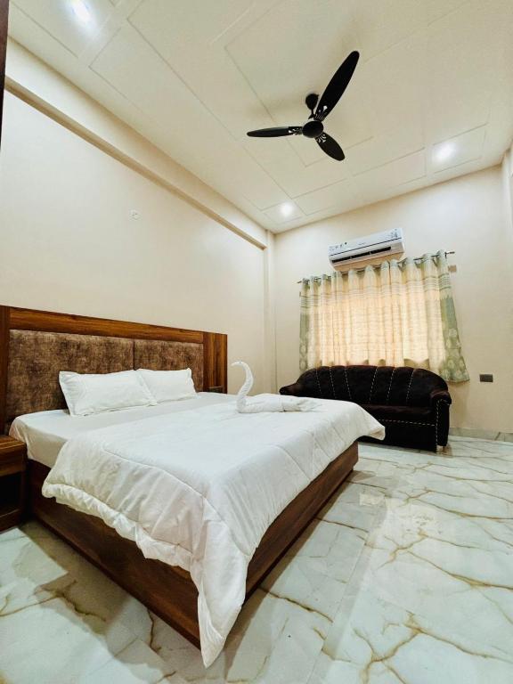 a bedroom with a large bed and a ceiling fan at Hotel Tara Grand in Mathura