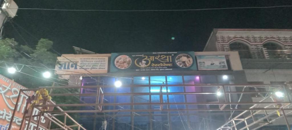 a building with a sign on top of it at night at Astha Restorent & Geust House in Aonla