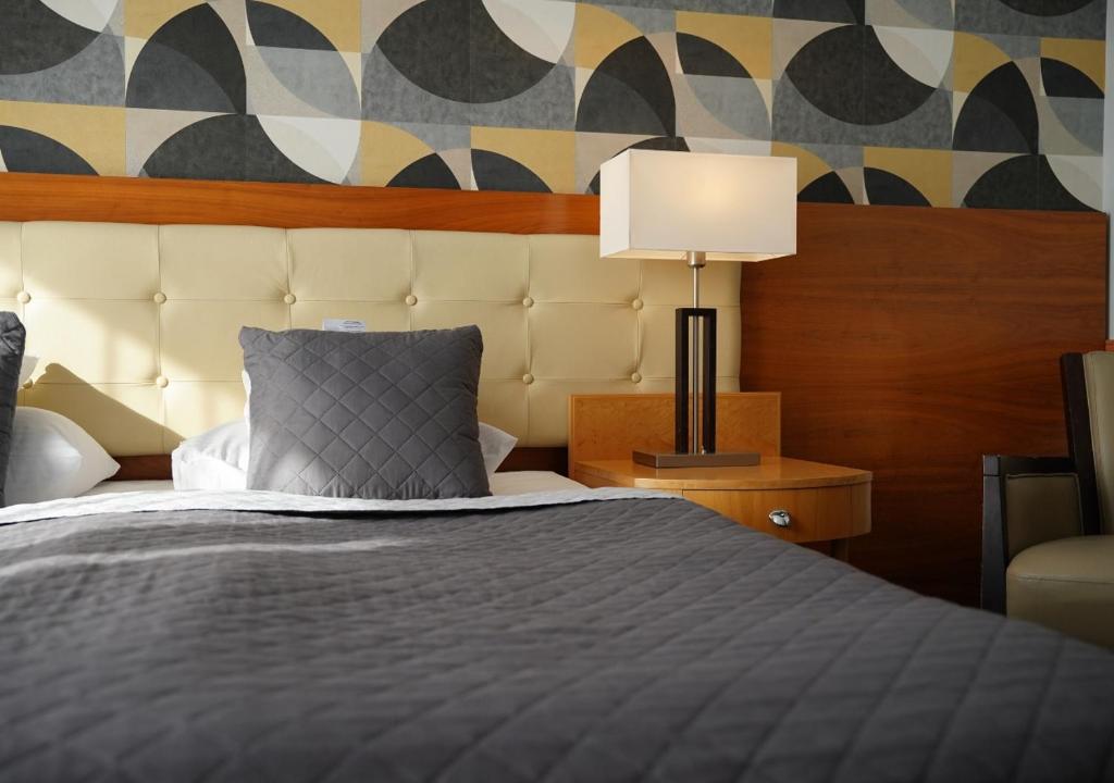 a bedroom with a bed and a lamp on a table at Platinum Ostróda in Ostróda