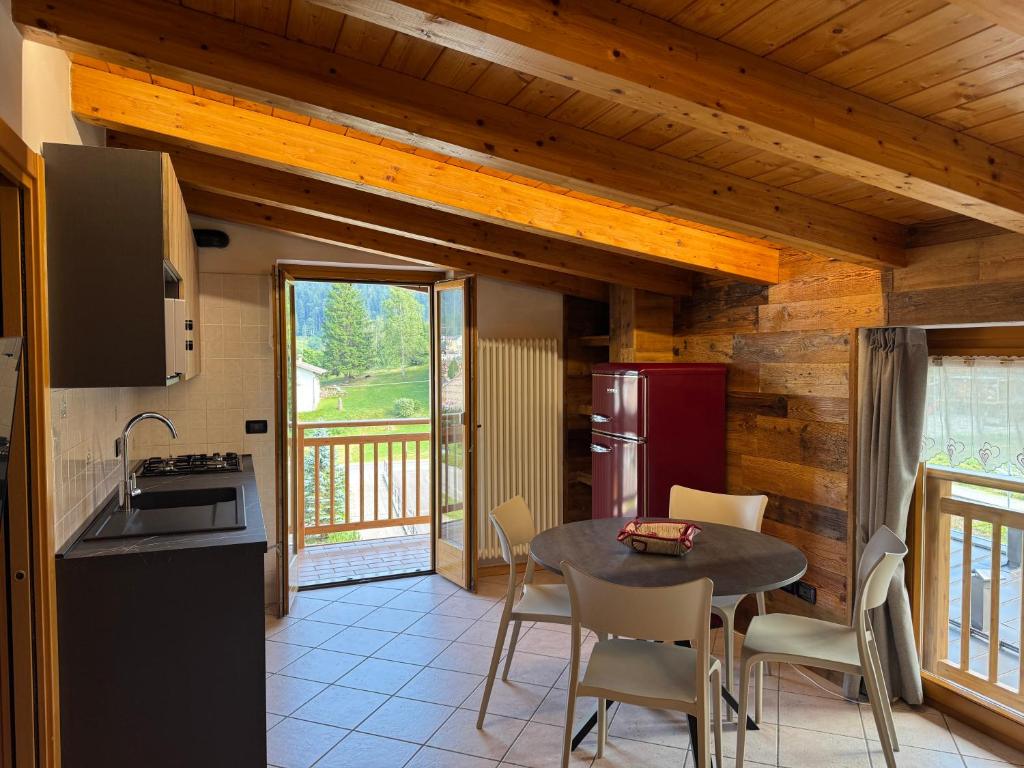 a kitchen and dining room with a table and chairs at Bilocale baciato dal sole in Andalo