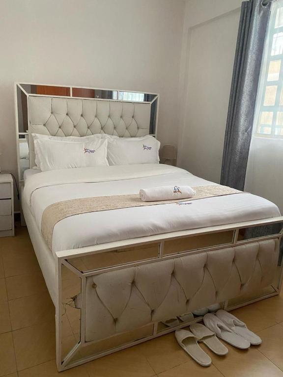 a bedroom with a large bed with two pairs of shoes at Esskayhomestays in Eldoret