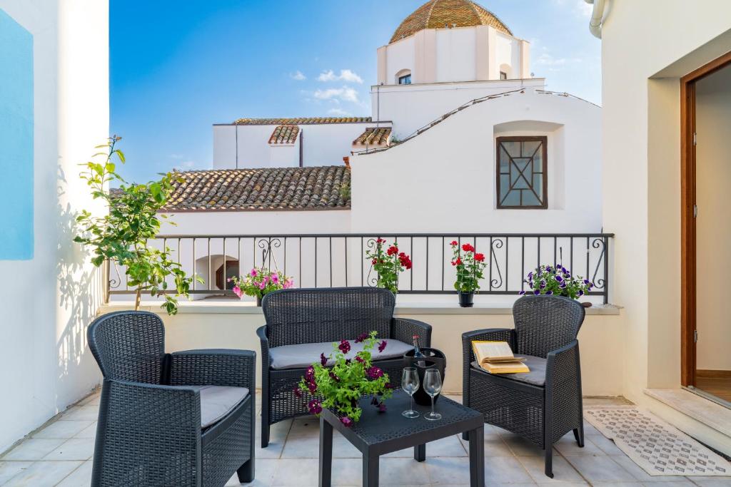 a patio with chairs and tables and a building at Stentadì Guest House Tortolì in Tortolì