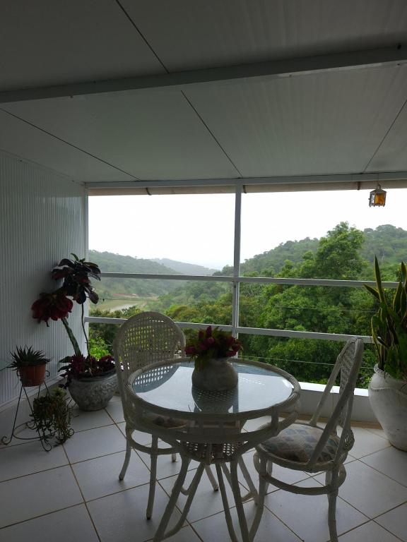 a table and chairs on a balcony with a view at Pousada Brasil Tropical in Bezerros