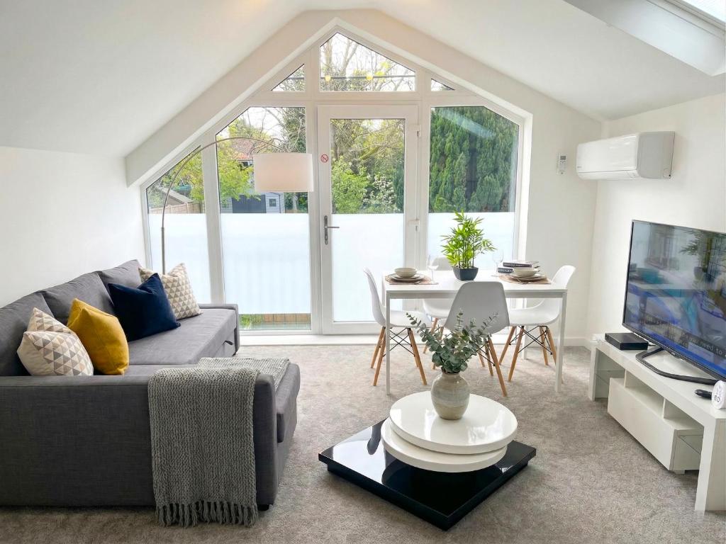 a living room with a couch and a table with a tv at Walnut Flats-F3, 1-Bedroom with Stunning Garden View, AC, Parking, Netflix, WIFI - Close to Oxford, Bicester & Blenheim Palace in Oxford