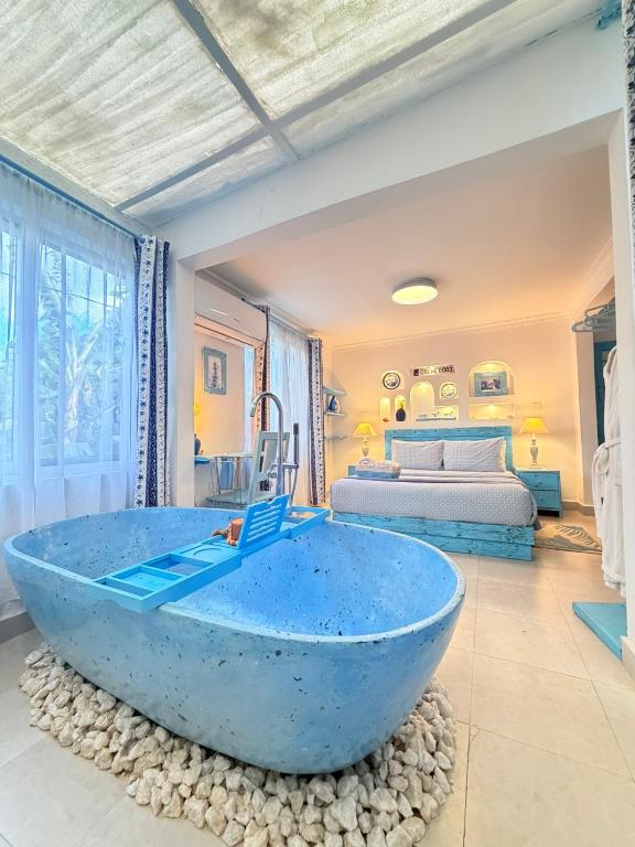 a large blue tub in a room with a bedroom at Studio Bleu by The Prime Escape in Arusha