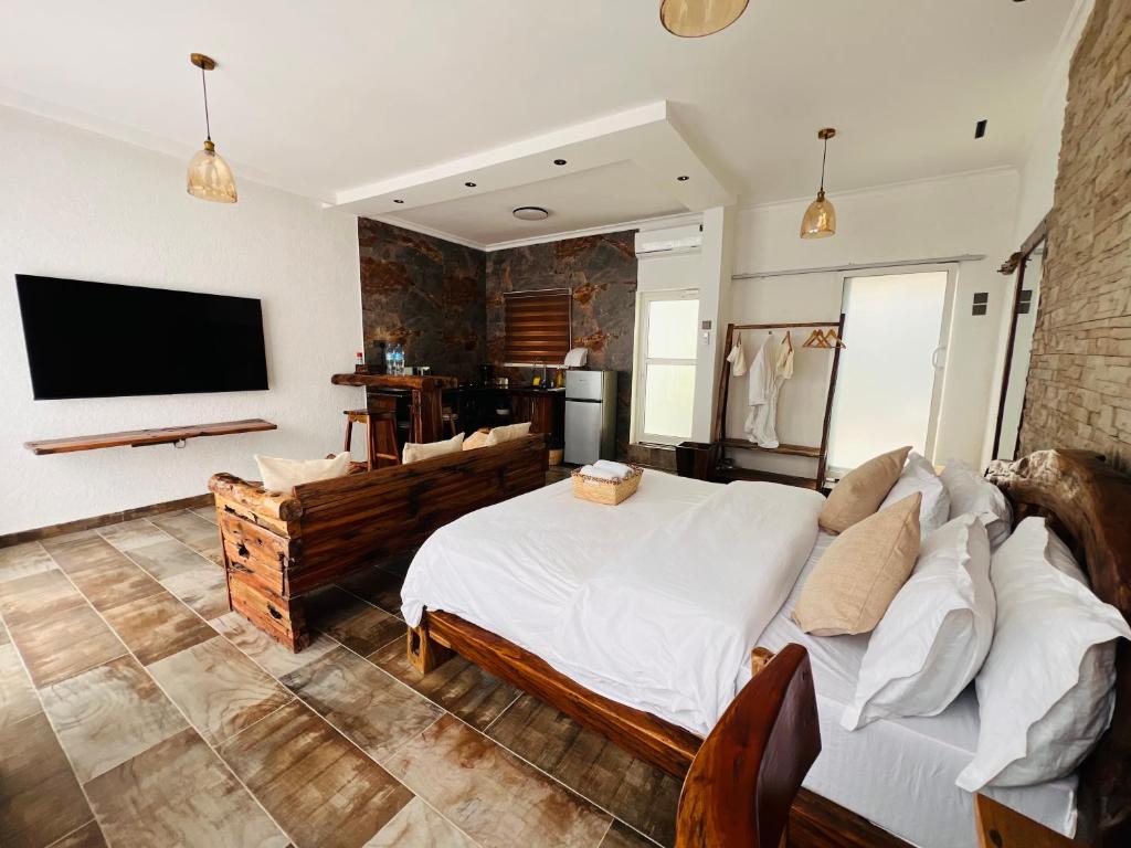 a bedroom with a large bed and a tv at City Retreat Mega in Arusha
