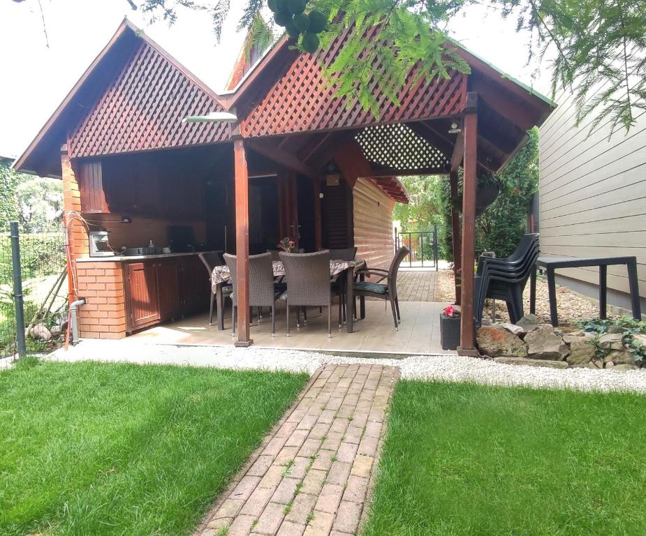 a pavilion with a table and chairs on a patio at Ciprus nyaraló in Szarvas