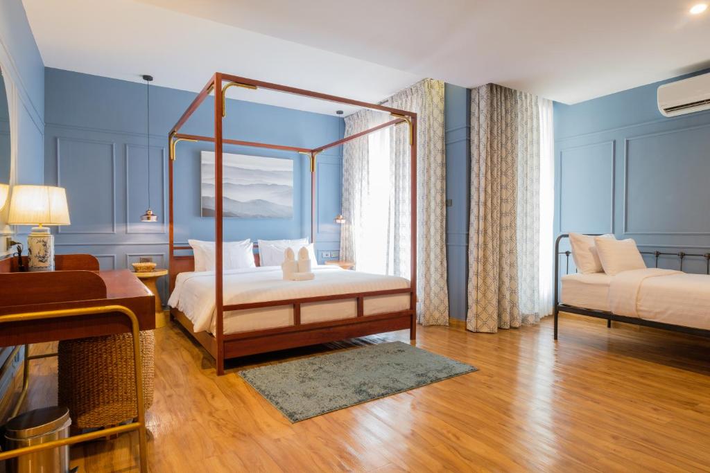 a bedroom with a canopy bed in a room at The Craft Nimman in Chiang Mai