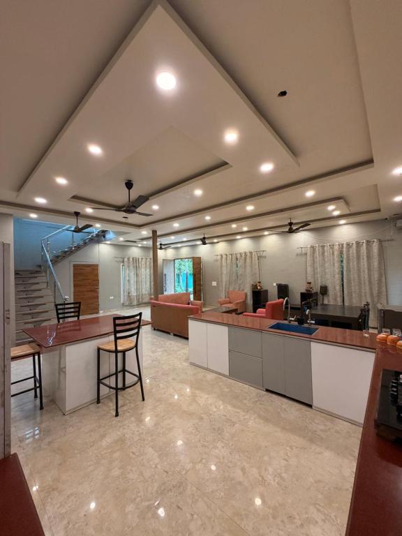 a large kitchen and living room with a table and chairs at The Machan Farmhouse in Noida