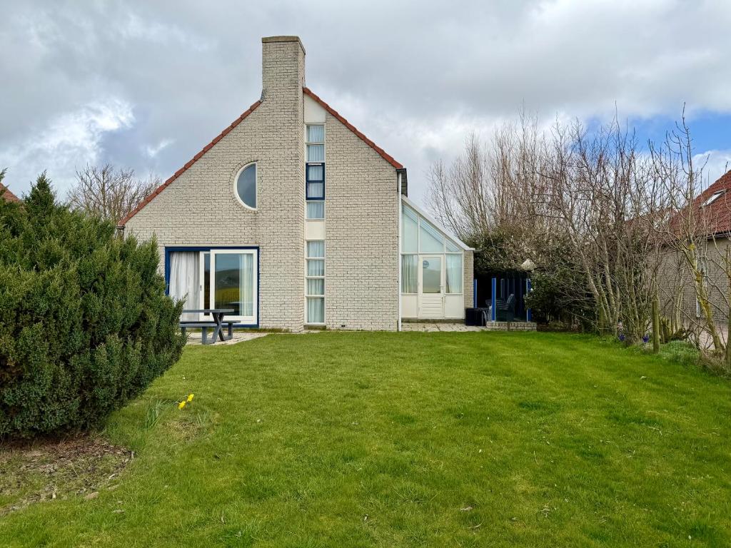 a house with a lawn in front of it at Villa Tulp & Duin in Julianadorp