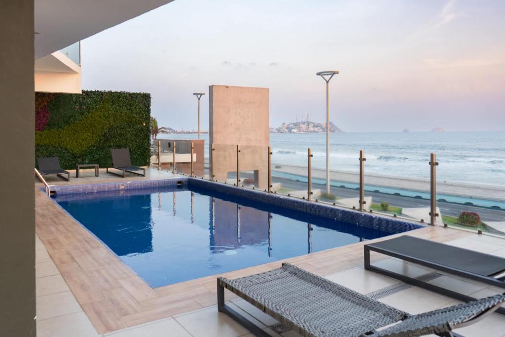 a swimming pool with a view of the ocean at Luxurious 2 bedroom condo with partial ocean view in Mazatlán