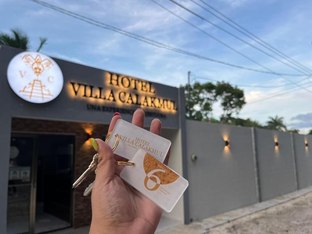 a person holding a piece of food in front of a building at HOTEL VILLA CALAKMUL in Xpujil