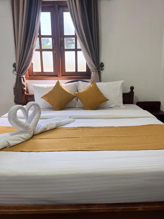 a bed with two white towels in the shape of a heart at Regal Montara in Nuwara Eliya