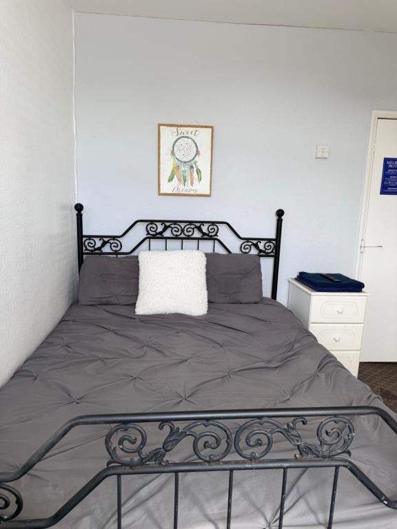a bedroom with a bed with a black metal frame at Melrose Hotel in Blackpool