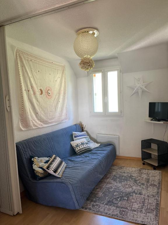 a blue couch in a living room with a window at Charmant appartement avec vue montagne in Luz-Saint-Sauveur