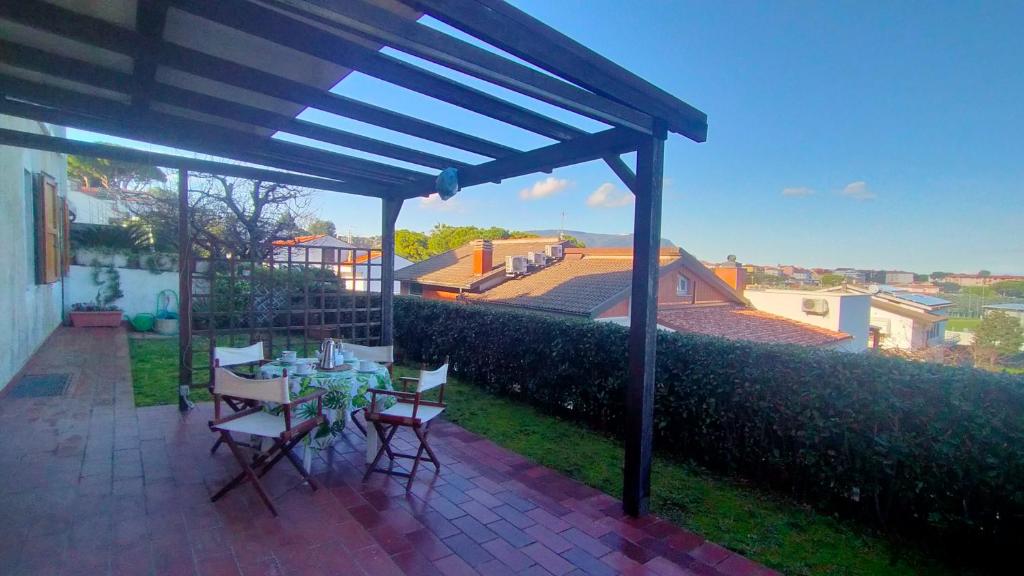 a patio with a table and chairs under a pergola at TRILOCALE CON GIARDINO E POSTO AUTO- cod 504 in Marcelli