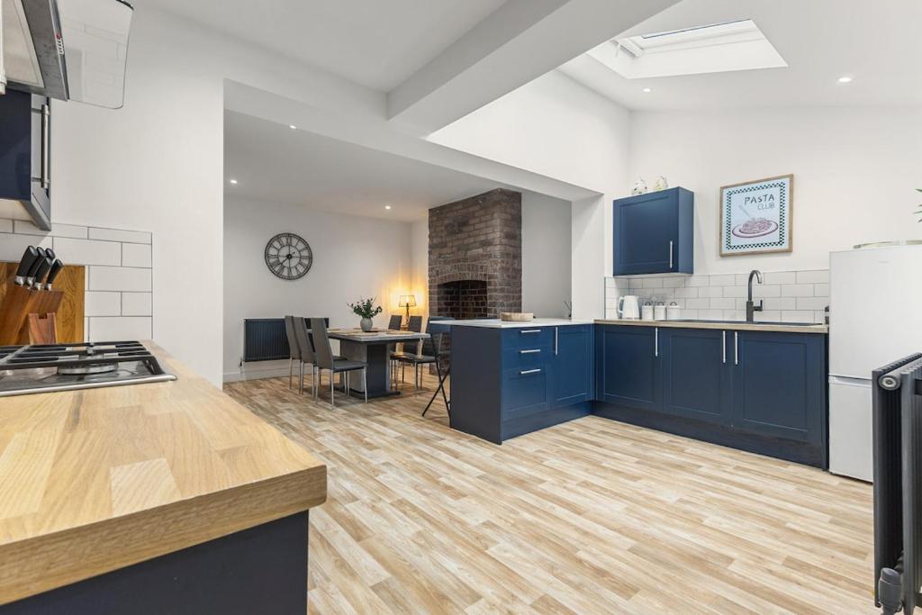 a kitchen with blue cabinets and a table in it at Potovens Place in Lofthouse Gate