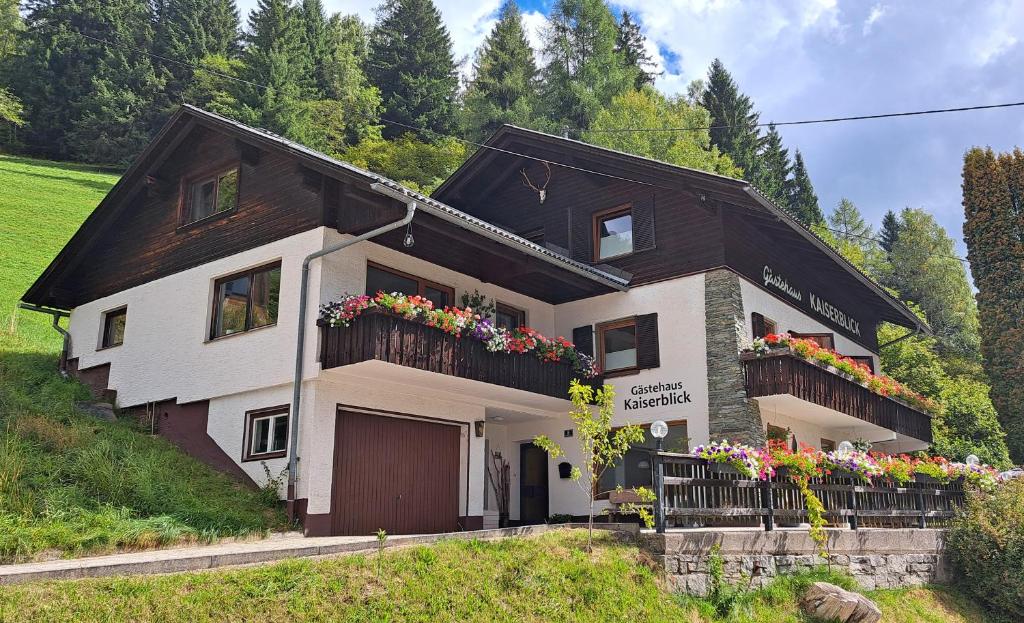 a house with flowers on the balconies of it at Gästehaus Kaiserblick in Bad Kleinkirchheim