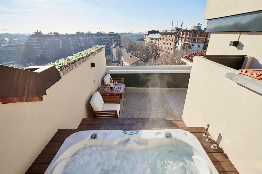 a hot tub on the balcony of a building at Conca9, Luxury attic with jacuzzi in Navigli in Milan