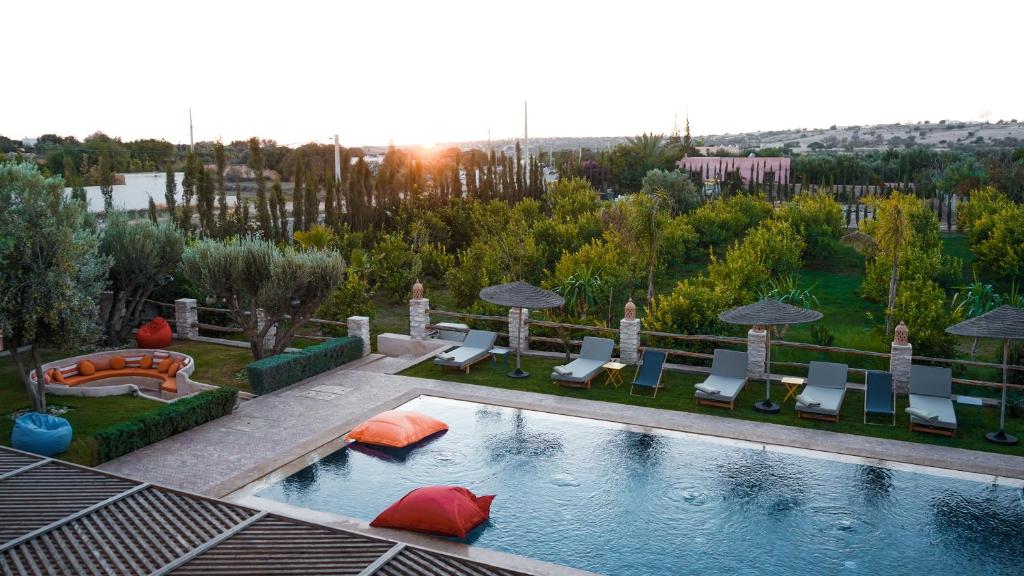 a swimming pool with chairs and umbrellas on a resort at Dar Eddihi Essaouira in Essaouira