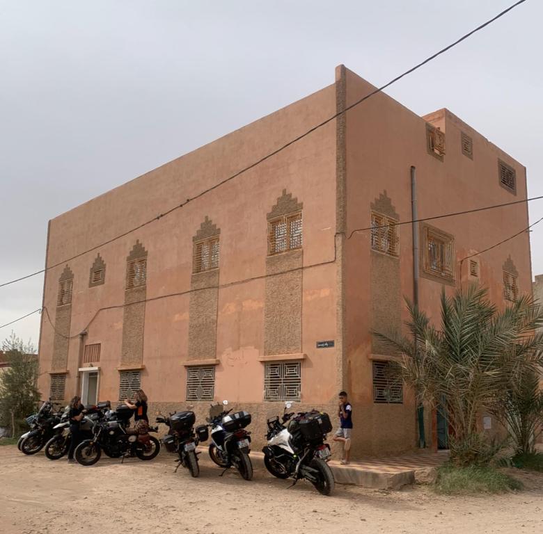 a group of motorcycles parked in front of a building at Tinejdad Auberge in Tinejdad