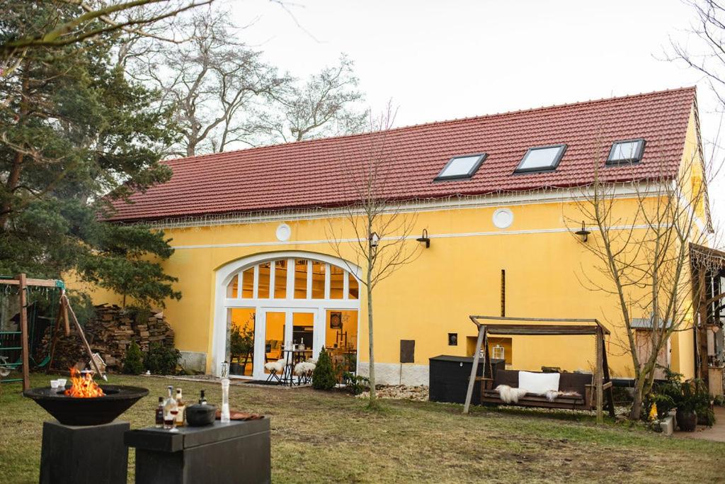 a large yellow house with a roof at Farma Mlýn Drásov in Drásov
