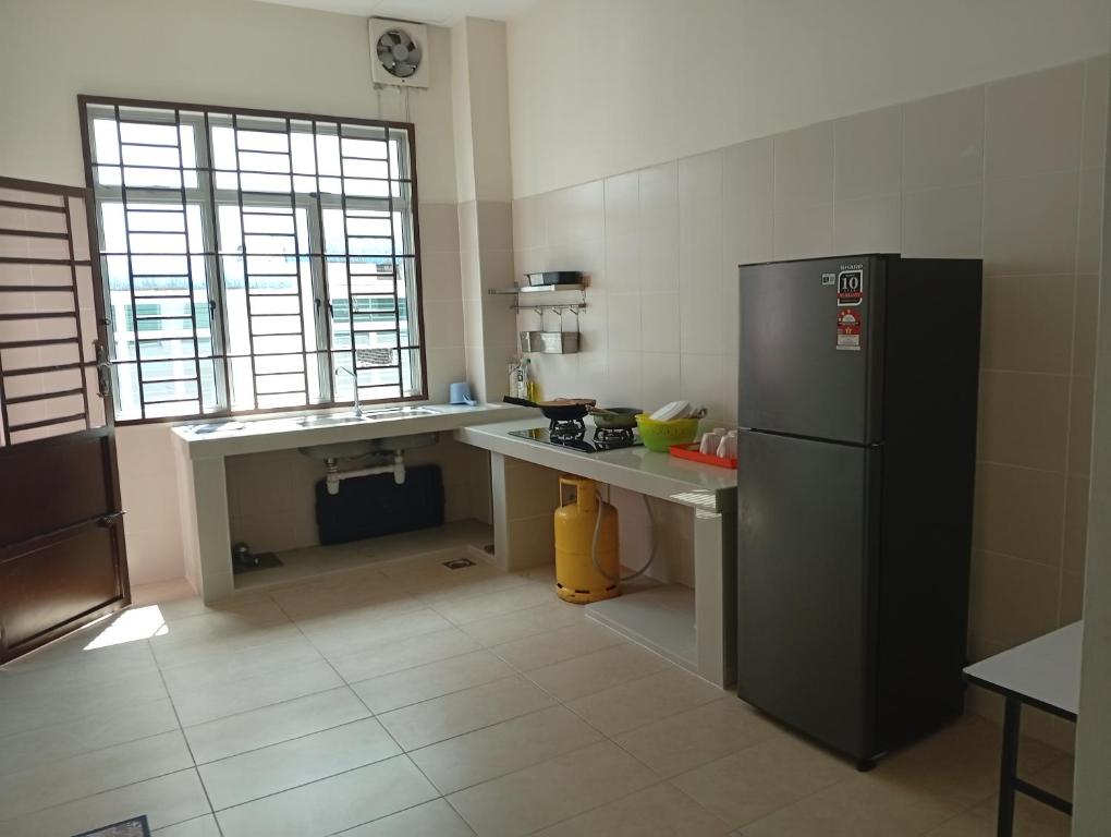 a kitchen with a refrigerator and a table in it at Alpha 2 in Johor Bahru