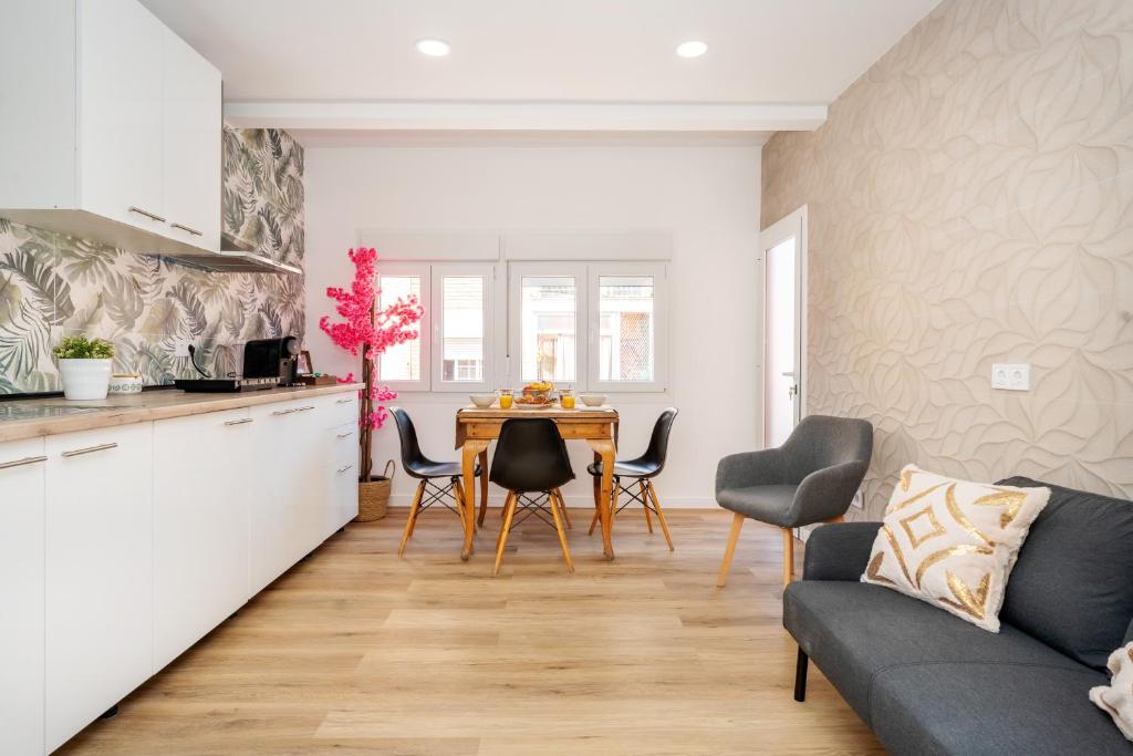 a kitchen and living room with a table and chairs at Bright Renovated 2BR Apt- Balcony - Beach 10' Walk - Barcelona 25' Train in Sant Adria de Besos