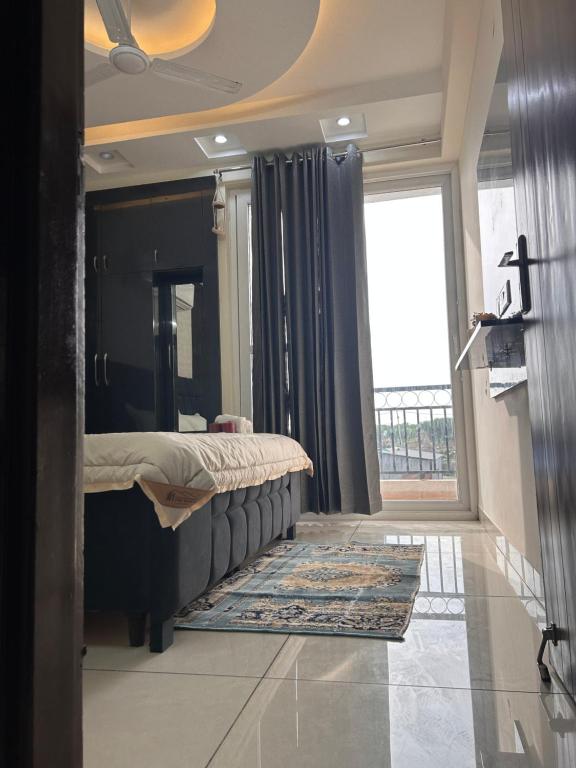 a bedroom with a bed and a large window at Sukhhin Chandigarh in Zirakpur