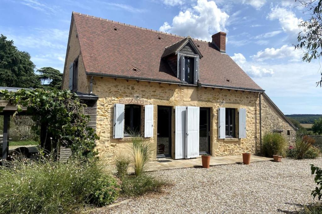 an old stone house with white doors at La Maison de Fougerolles, Renovated farmhouse in Fougerolles