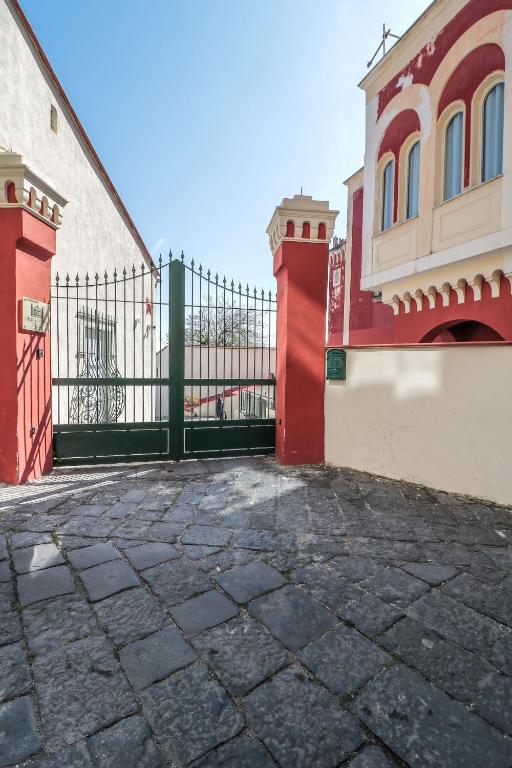 a gate in front of a building with a red fence at Dimora Gioia in Ercolano
