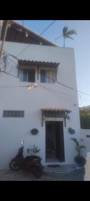 a motorcycle parked in front of a white building at Casa Valhalla Pipa in Pipa