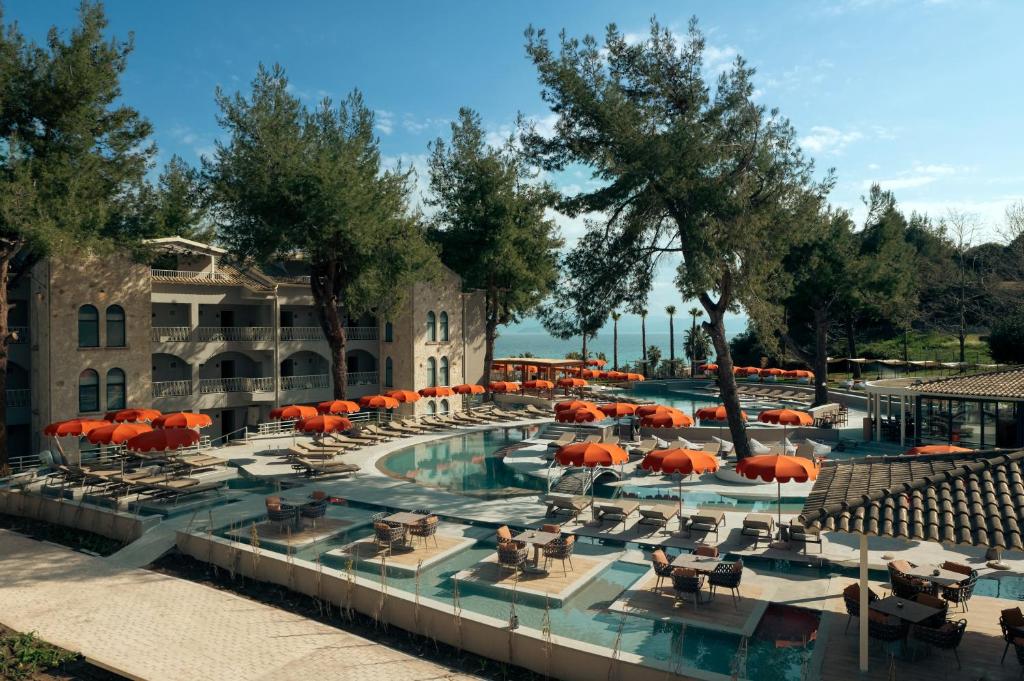 a pool at a resort with chairs and umbrellas at Zeus Eleva Kassandra Lagoon in Hanioti