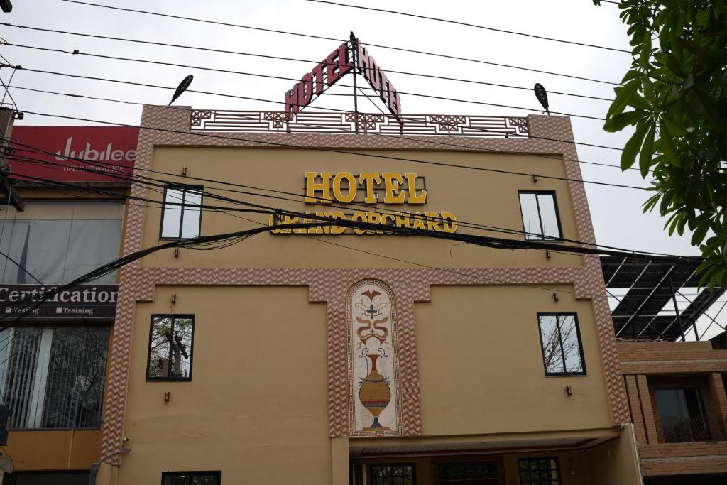 a building with a sign on top of it at Hotel Grand Orchard in Lahore